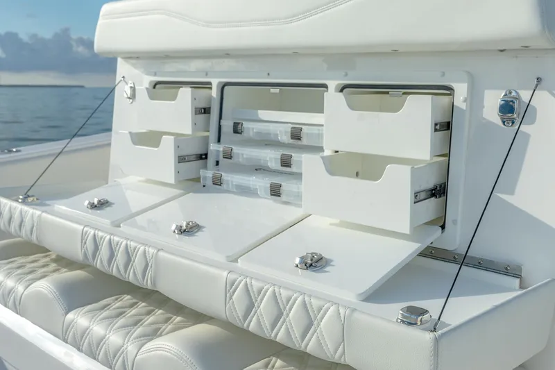Slide: The Image of 2022 Invincible 33 Catamaran storage compartments with open drawers and cushioned seating. - 16