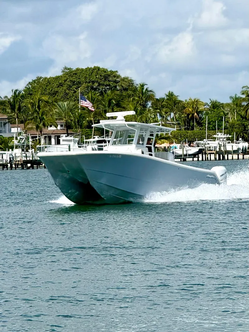 Slide: The Image of 2022 Invincible 33 Catamaran cruising on a sunny day near a coastal area. - 2