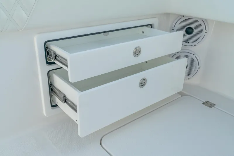 Slide: The Image of White storage drawers on 2022 Invincible 33 Catamaran, featuring sleek design and integrated speakers. - 20