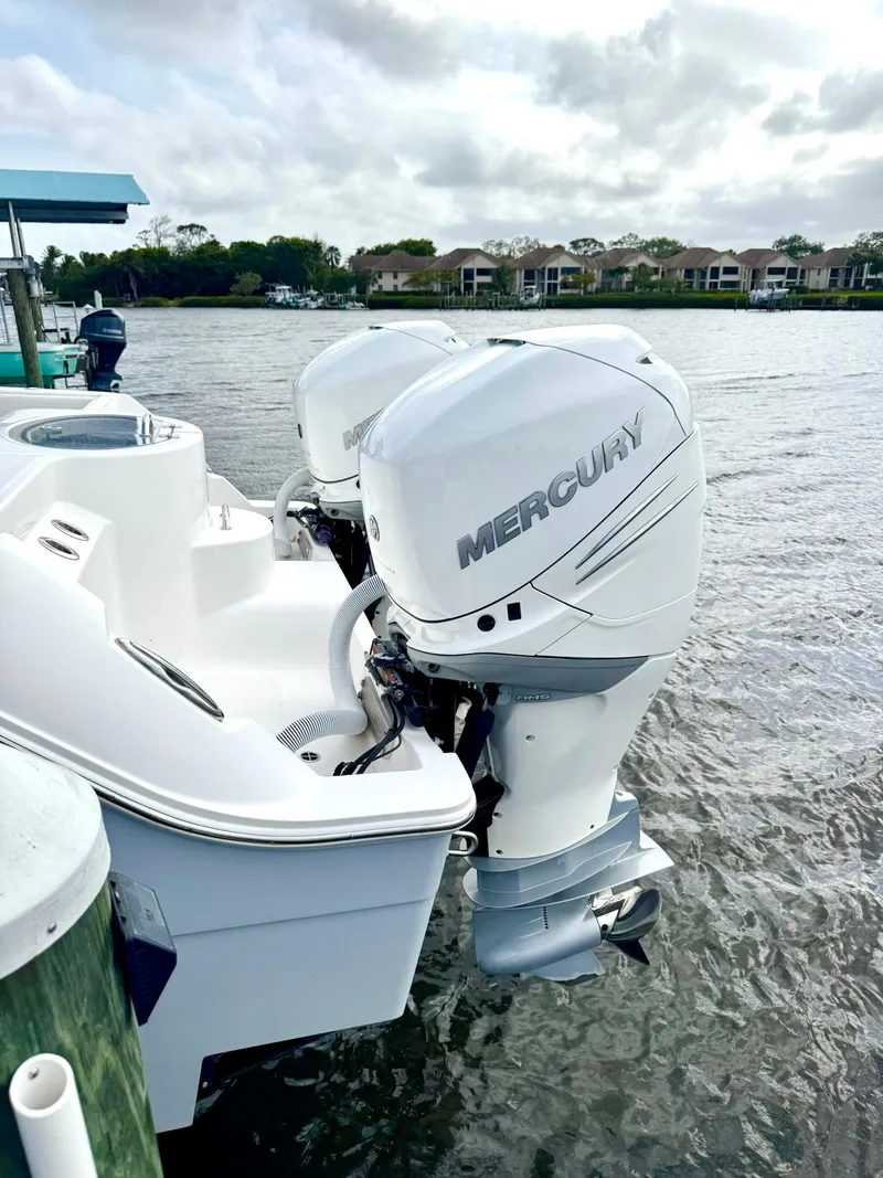 Slide: The Image of 2022 Invincible 33 Catamaran with twin Mercury outboard engines docked by the water. - 23