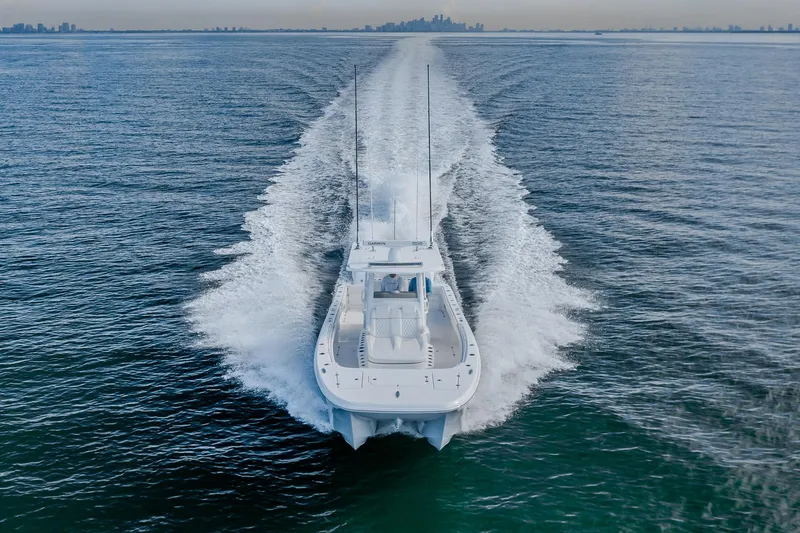Slide: The Image of 2022 Invincible 33 Catamaran cruising on open water, city skyline in background. - 24
