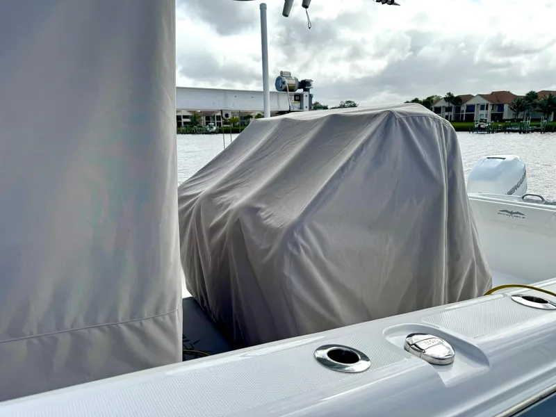 Slide: The Image of Covered console on 2022 Invincible 33 Catamaran, docked by waterfront homes. - 30