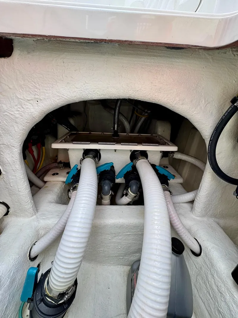 Slide: The Image of Engine compartment of 2022 Invincible 33 Catamaran with visible hoses and fittings. - 33