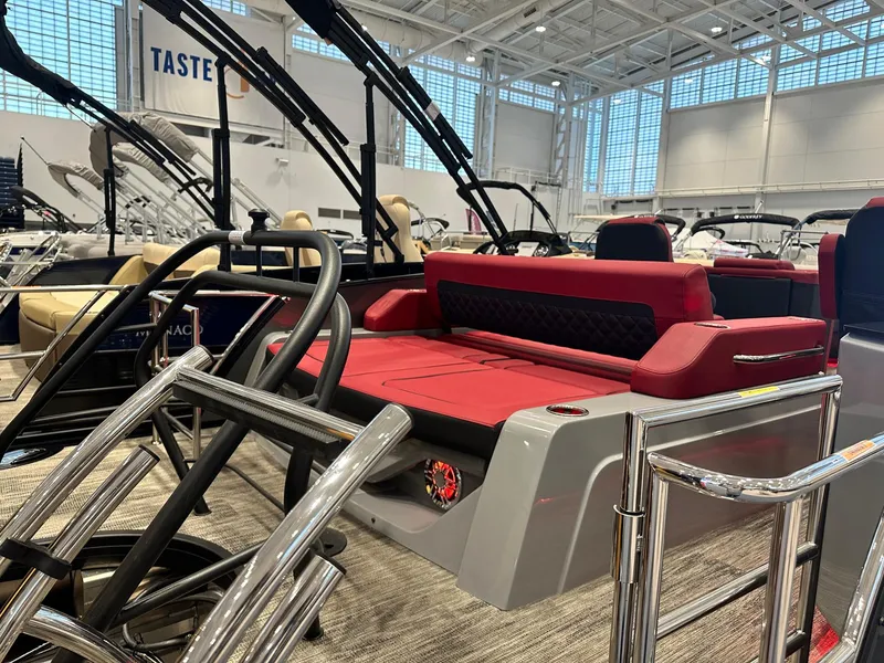 Slide: The Image of 2024 Godfrey AquaPatio 235 SFLC boat with red seating in a showroom. - 8