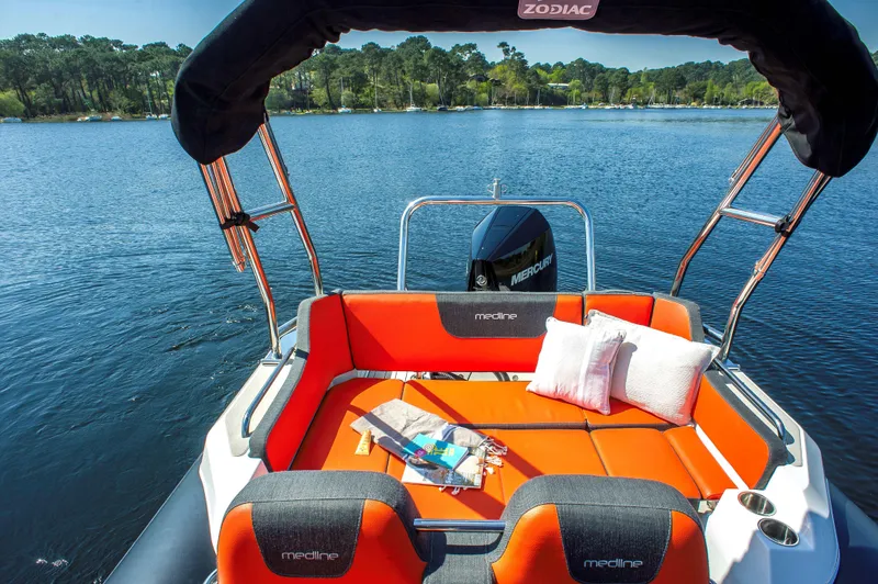 Slide: The Image of 2025 Zodiac Medline 6.8 boat with orange seating, on a serene lake. - 12