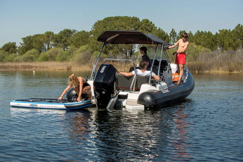 Slide: The Image of 2025 Zodiac Medline 6.8 boat with people enjoying water activities on a sunny day. - 6