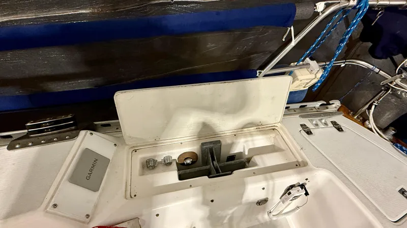 Slide: The Image of 1989 J Boats J/40 cockpit with open storage compartment and Garmin equipment. - 11