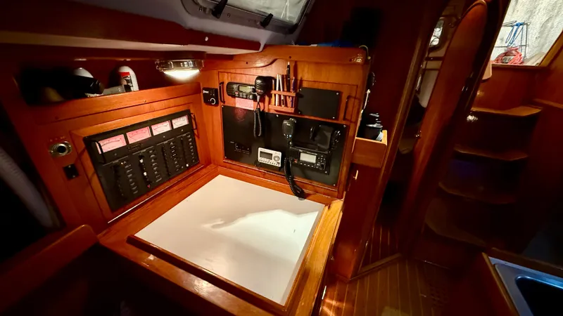 Slide: The Image of 1989 J Boats J/40 interior navigation station with control panels and wooden finish. - 30