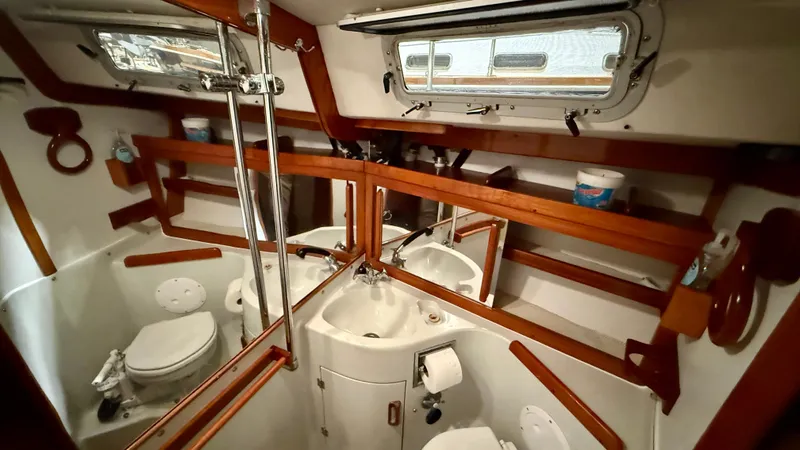 Slide: The Image of 1989 J Boats J/40 yacht bathroom with wooden accents and compact design. - 33