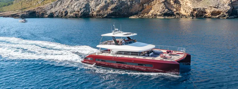 Slide: The Image of 2025 Lagoon SIXTY 7 yacht cruising near rocky coastline. - 1