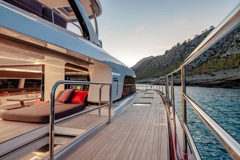 Slide: The Image of Luxurious 2025 Lagoon SIXTY 7 yacht deck with scenic coastal view at sunset. - 7