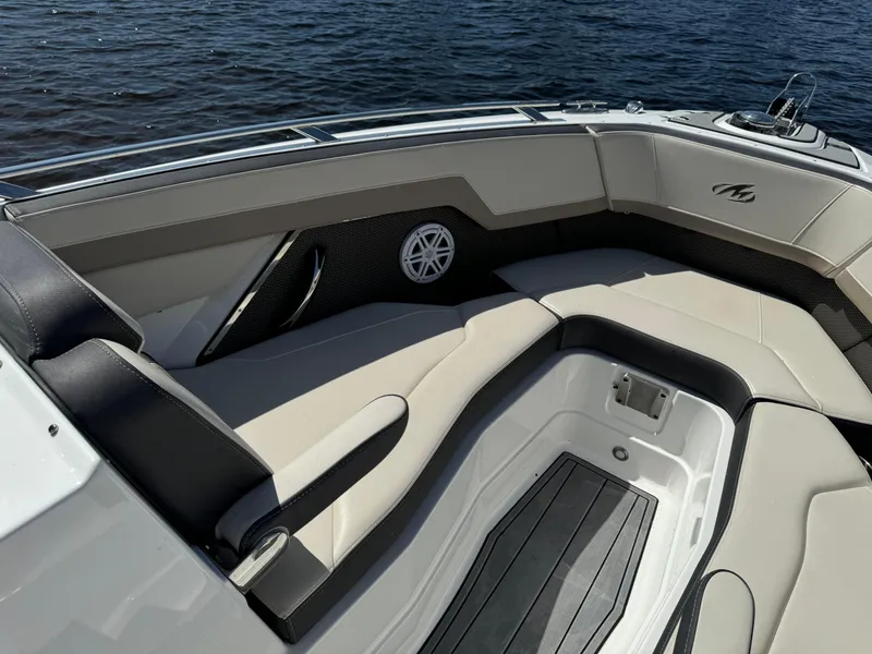 Slide: The Image of 2022 Monterey 278 Super Sport boat interior with cushioned seating and speaker, on calm water. - 16