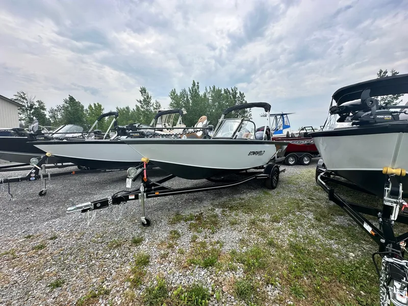 The Image of 2024 Starweld Victory 18 DC boat on trailer, displayed outdoors on gravel lot. - 0