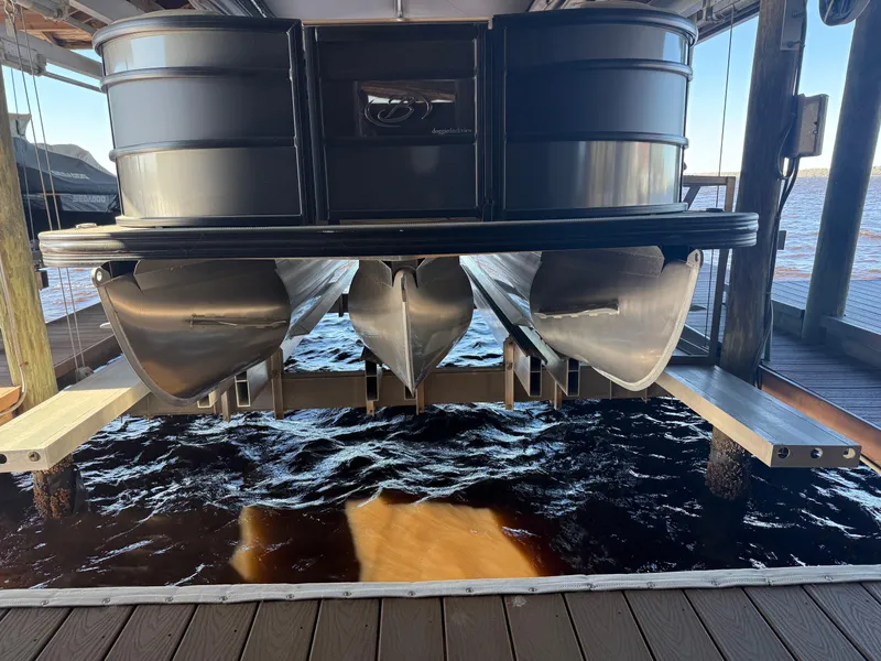 Slide: The Image of 2022 Barletta Lusso 23U pontoon boat on lift over water. - 12