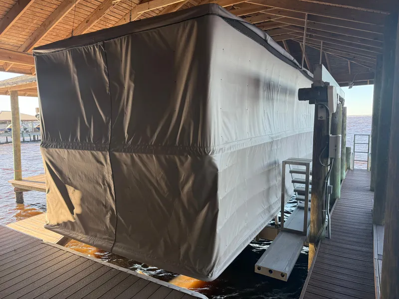 Slide: The Image of Covered 2022 Barletta Lusso 23U pontoon boat docked in a wooden boathouse. - 14