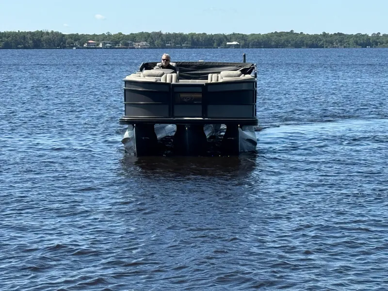 Slide: The Image of 2022 Barletta Lusso 23U pontoon boat cruising on a calm lake. - 2
