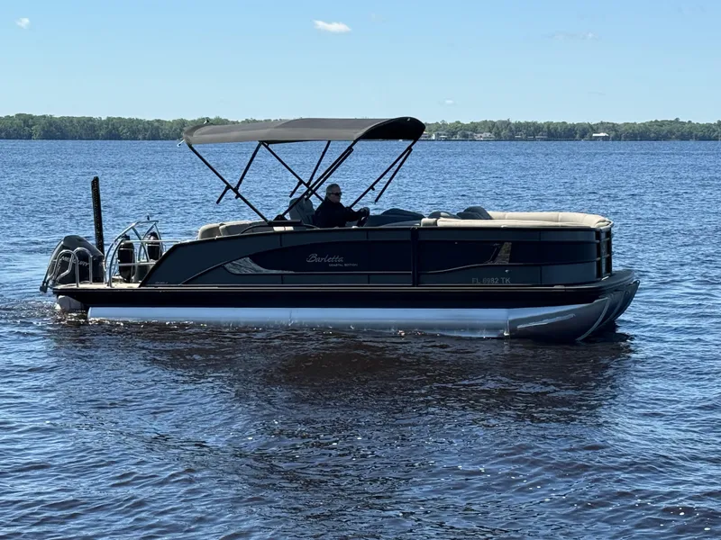 Slide: The Image of 2022 Barletta Lusso 23U pontoon boat cruising on a calm lake. - 3