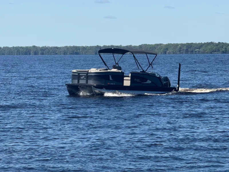 Slide: The Image of 2022 Barletta Lusso 23U pontoon boat cruising on a serene lake. - 33
