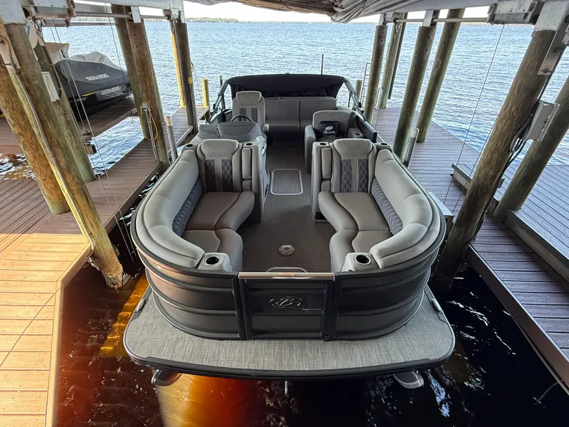 Slide: The Image of 2022 Barletta Lusso 23U pontoon boat docked, featuring spacious seating and elegant design. - 7