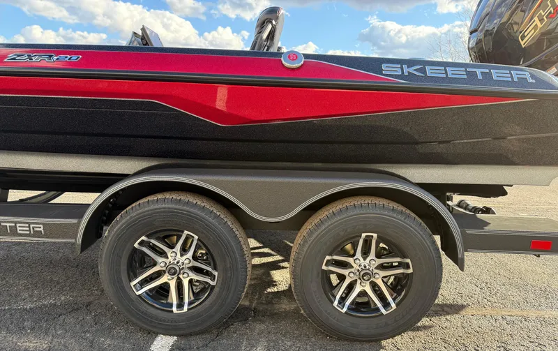 Slide: The Image of 2025 Skeeter ZXR20 boat on trailer, featuring sleek red and black design with dual wheels. - 11