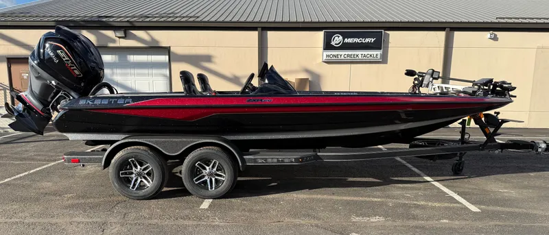 Slide: The Image of 2025 Skeeter ZXR20 bass boat on trailer, parked outside Honey Creek Tackle. - 4