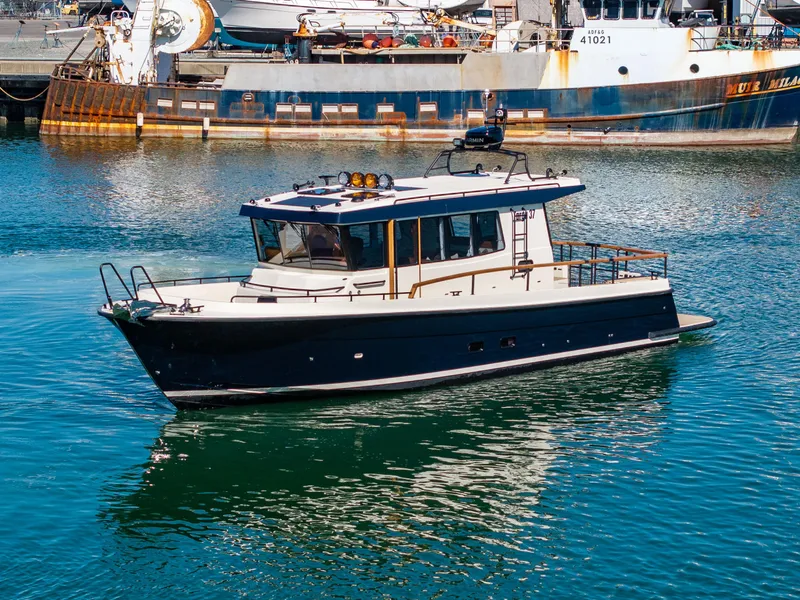 The Image of 2025 Targa 37 boat cruising in a harbor with industrial background. - 0