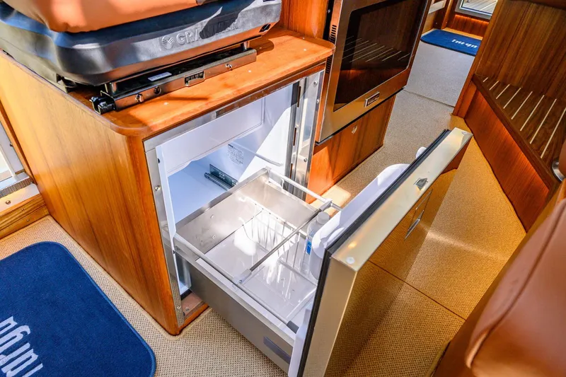 Slide: The Image of 2025 Targa 37 yacht interior with open fridge and wooden cabinetry. - 14
