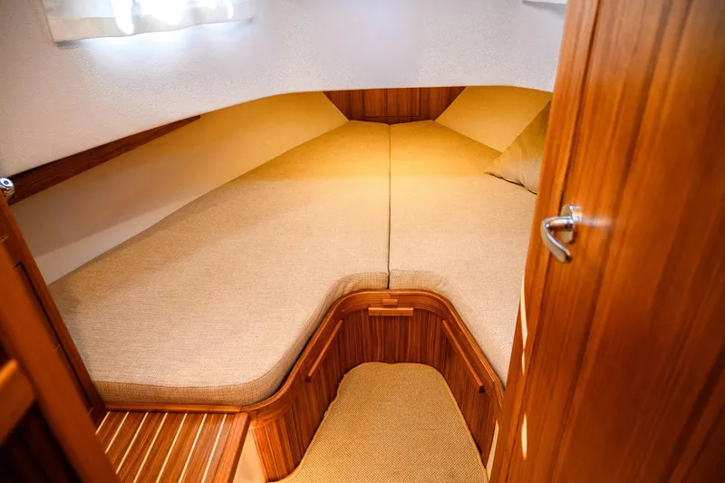 Slide: The Image of Cozy cabin interior of 2025 Targa 37 boat with wooden finish and beige bedding. - 21