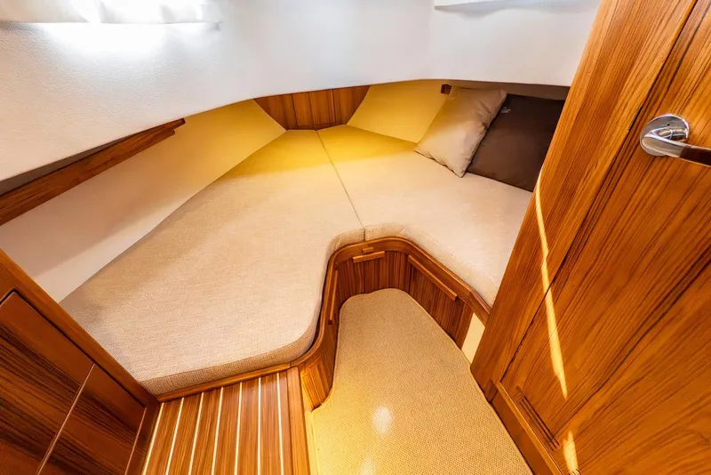 Slide: The Image of 2025 Targa 37 cabin interior with wooden finish and cozy bedding. - 22
