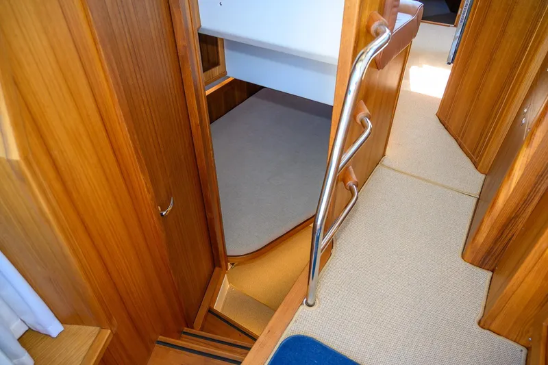 Slide: The Image of Interior of 2025 Targa 37 boat, featuring wooden paneling and carpeted flooring. - 27