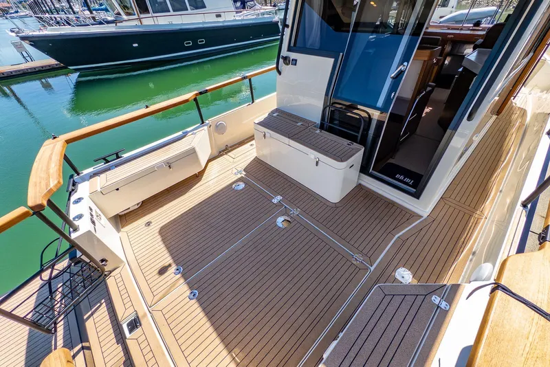 Slide: The Image of 2025 Targa 37 boat deck with teak flooring and seating, docked in a marina. - 32