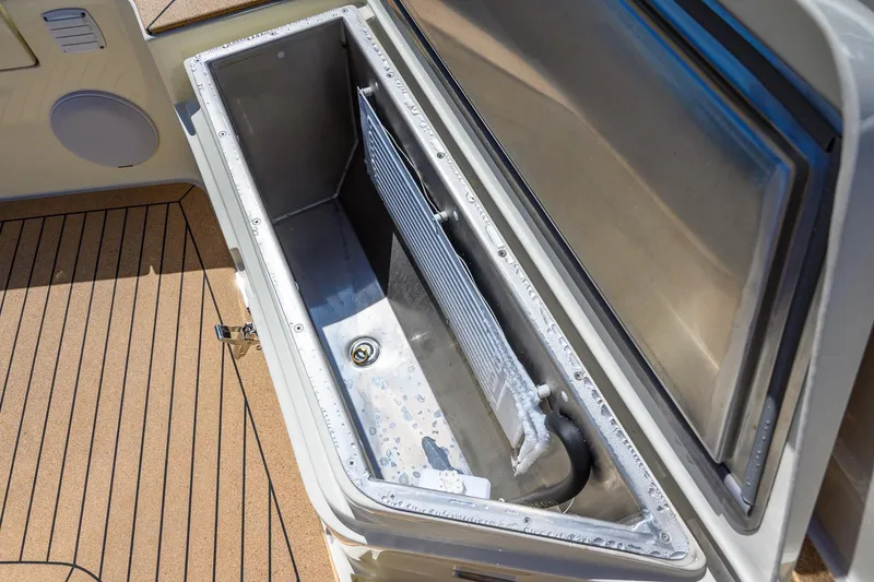 Slide: The Image of Open storage compartment on 2025 Targa 37 boat with teak flooring. - 37