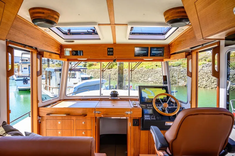 Slide: The Image of Interior of 2025 Targa 37 boat, featuring wooden helm, navigation screens, and marina view. - 4