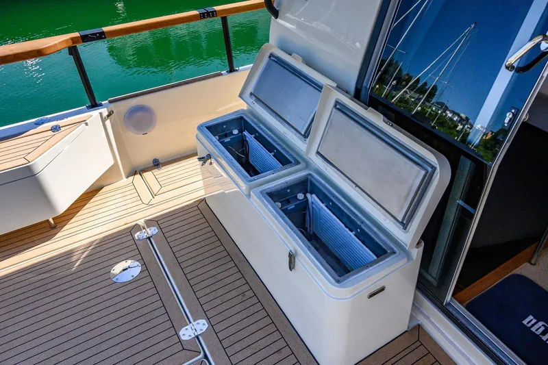 Slide: The Image of 2025 Targa 37 yacht deck with open storage compartments and teak flooring. - 49