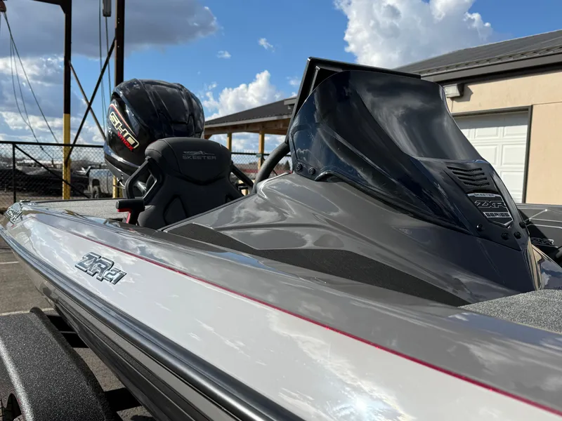 Slide: The Image of 2025 Skeeter ZXR21 boat with sleek design and powerful engine, under a partly cloudy sky. - 11