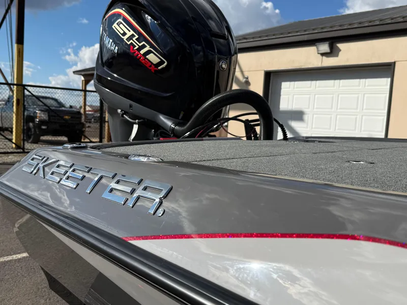 Slide: The Image of 2025 Skeeter ZXR21 boat with Yamaha engine, parked outdoors. - 13