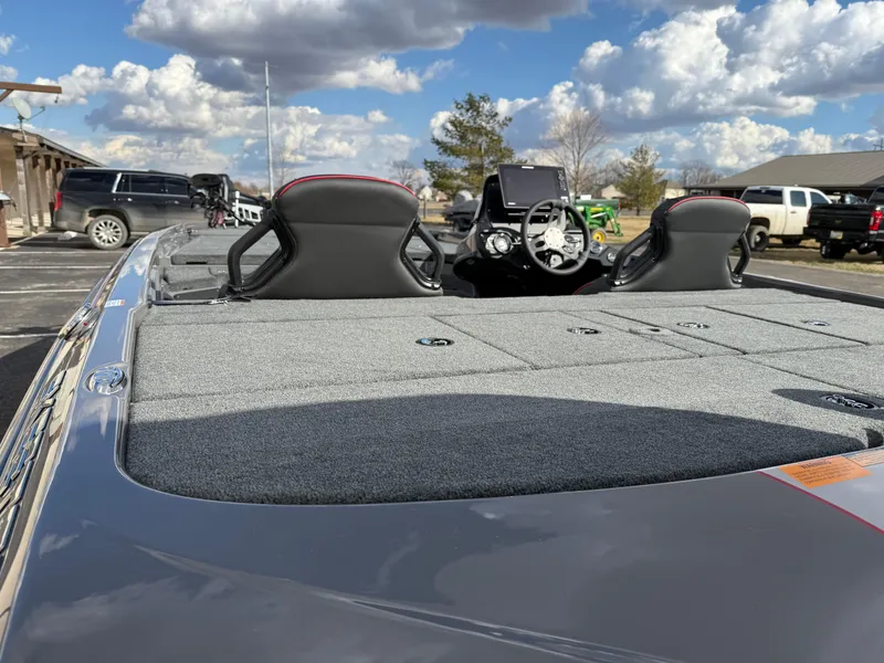 Slide: The Image of 2025 Skeeter ZXR21 boat interior with dual seats and steering console under a cloudy sky. - 16