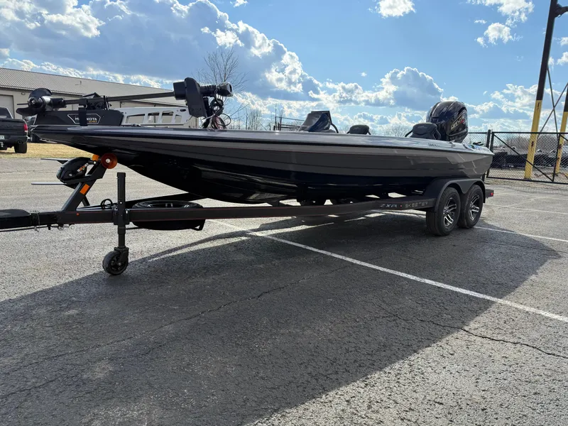Slide: The Image of 2025 Skeeter ZXR21 boat on trailer under a partly cloudy sky. - 2