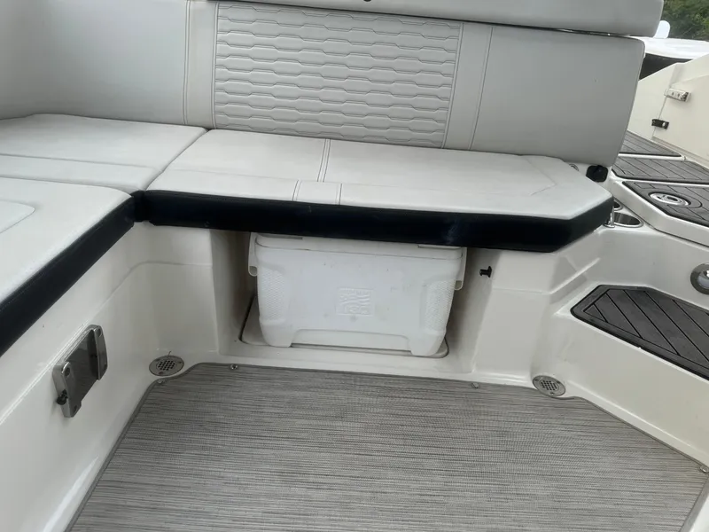 Slide: The Image of 2022 Sea Ray SPX 230 OB boat interior with cushioned seating and storage compartment. - 17