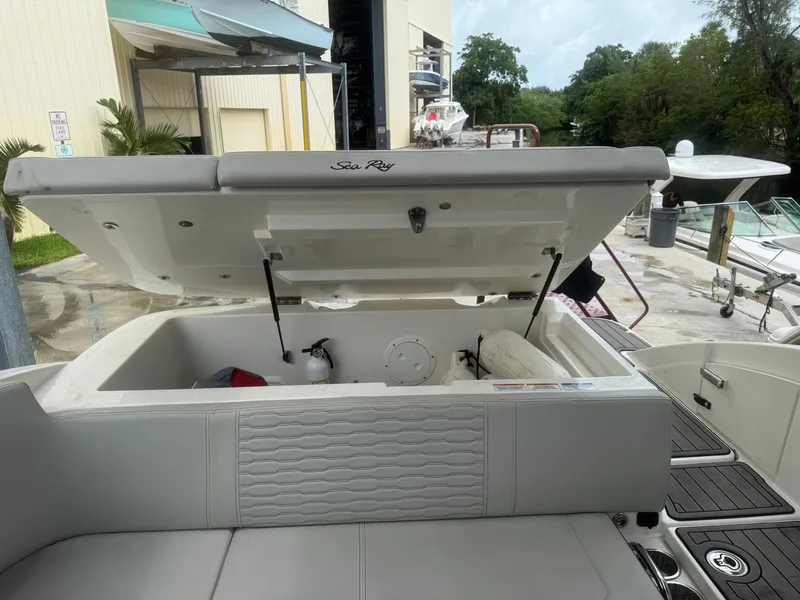 Slide: The Image of 2022 Sea Ray SPX 230 OB boat with open storage compartment at marina. - 18