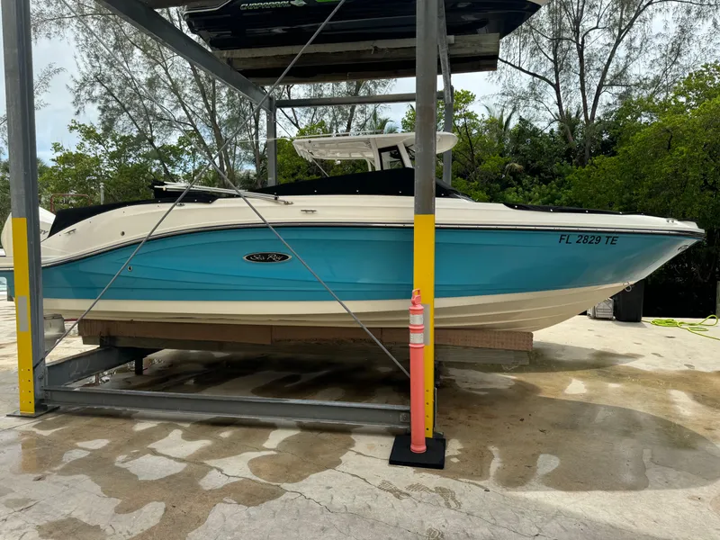 Slide: The Image of 2022 Sea Ray SPX 230 OB boat on a lift, blue hull, outdoor setting. - 2
