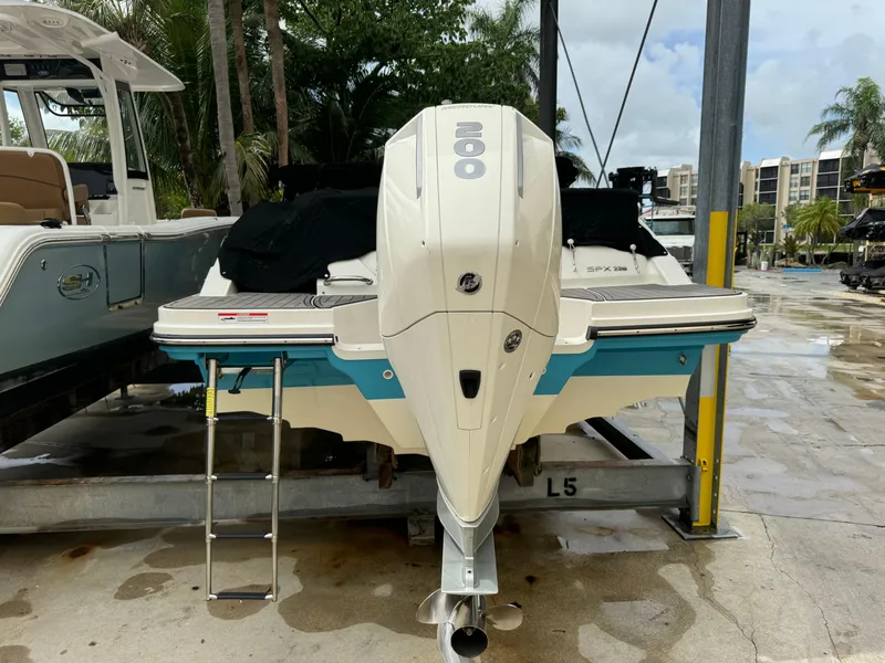 Slide: The Image of 2022 Sea Ray SPX 230 OB boat with outboard motor, docked on a lift. - 20