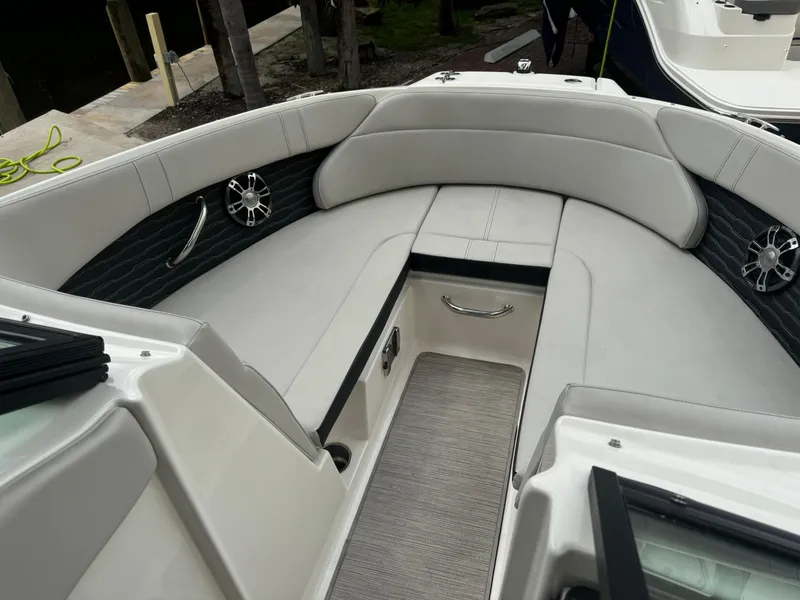 Slide: The Image of 2022 Sea Ray SPX 230 OB boat interior with cushioned seating and storage. - 7