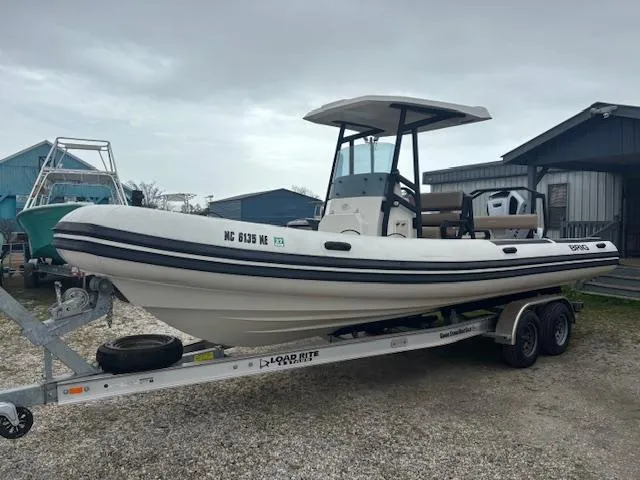 Slide: The Image of 2022 Brig Navigator 24 boat on trailer, parked outdoors, overcast sky. - 11