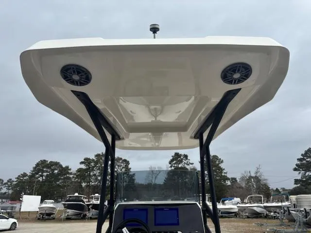 Slide: The Image of 2022 Brig Navigator 24 boat with canopy and speakers, parked in a marina. - 21