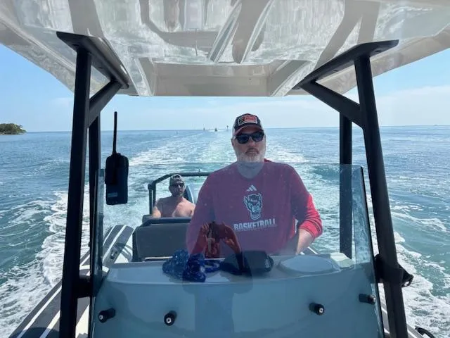 Slide: The Image of Two people on a 2022 Brig Navigator 24 boat cruising on open water. - 23