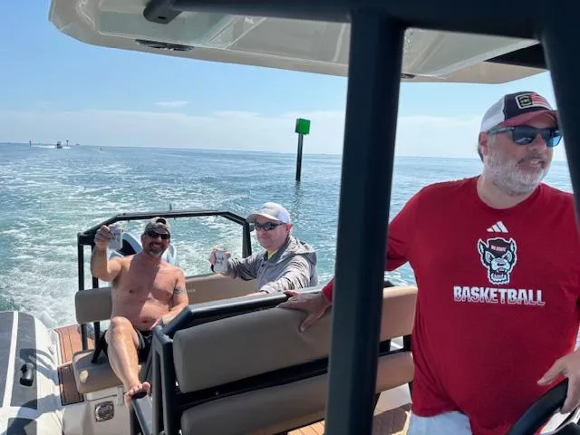 Slide: The Image of Three people enjoying a ride on a 2022 Brig Navigator 24 boat. - 24