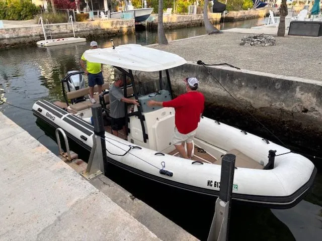Slide: The Image of 2022 Brig Navigator 24 boat docked with three people onboard in a canal setting. - 26