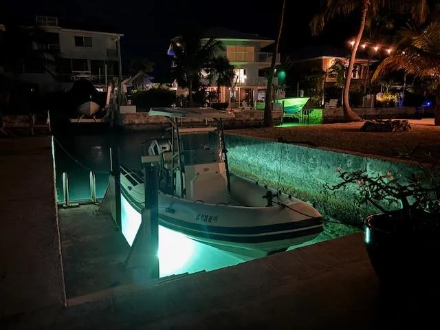 Slide: The Image of 2022 Brig Navigator 24 boat docked at night with underwater lights. - 27