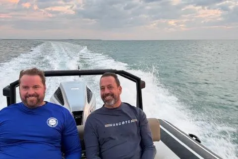 Slide: The Image of Two men enjoying a ride on a 2022 Brig Navigator 24 boat at sea. - 28